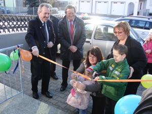Das Foto zeigt Landrat Georg Huber und den Bürgermeister der Gemeinde Schwindegg Dr. Karl Dürner bei der feierlichen Eröffnung des Bambini-Treffs zusammen mit den beiden Leiterinnen Carina Oeldenberger (1. v. rechts) und Patricia Rasch (kniend, 3. v. rechts).