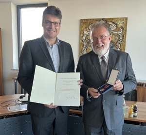 Das Bild der Pressestelle des Landratsamtes Mühldorf zeigt Landrat Max Heimerl (links) bei der Übergabe der Auszeichnung an Gerhard Fröhling aus Polling.